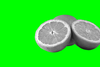 Grey-scale cross-sectional image of an orange showing segments, set against a vivid lime green background.