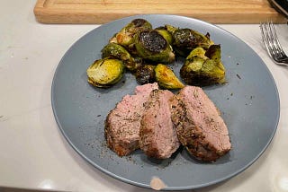 Pork tenderloin medallions and brussels sprouts, plated.