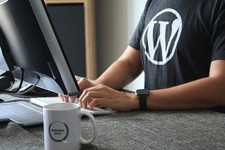 A person wearing WordPress t-shirt is working in front of the computer