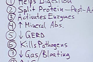 A note on a piece of paper listing items: “Helps Digestion, Split Protein, Activates Enzymes, Mineral Abs, GERD, Kills Pathogens, Gas/Bloating”