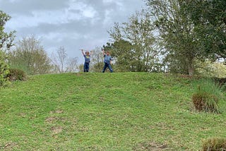Two boys stand on top of a hill, kings of the kingdom