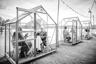 Guests of ETEN sitting inside greenhouses that the restaurant has converted into isolated dinning pods.