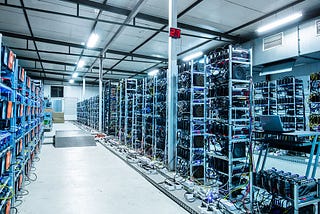A corridor of a server farm lined with tall racks of computers used for mining cryptocurrency.