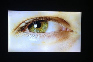 An eye with green iris: Medium is watching you, and wants you to gain 100 followers.