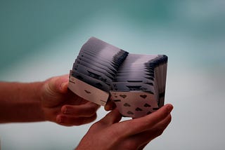 Hands shuffeling a deck of playing card.