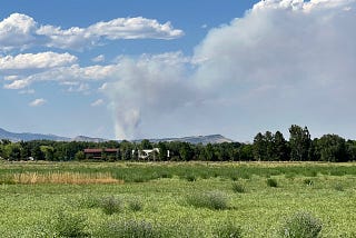 Field and mountains with fire plume from Alexander Mountain Fire on Monday, July 29, 2024. Photo by the author