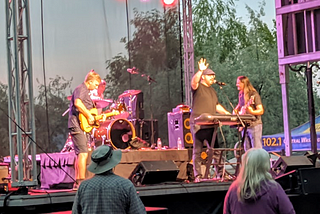 A band plays on a stage while people watch.