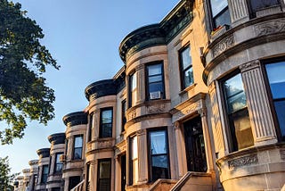 A block of brownstone apartments in Brooklyn as the sun sets