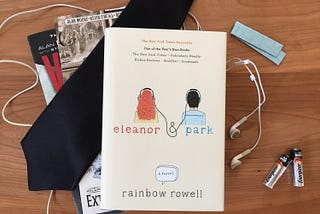 the book eleanor and park is sitting on a table with earbuds strung across