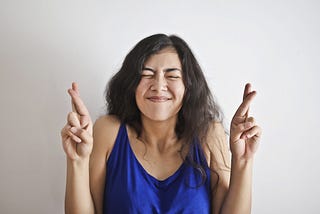 Smiling woman, crossing fingers