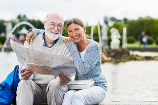 senior couple travelers looking at map