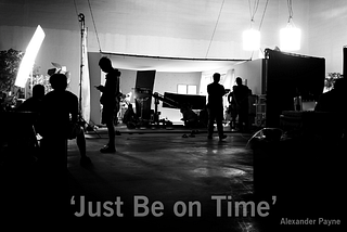A black and white, backlit image of a film set with “Just Be on Time”, a quote attributed to Alexander Payne, at the bottom of the image in the foreground.