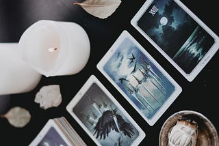 Tarot cards on a table with lit candles