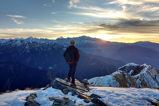 person standing on top of the mountain facing sunrise