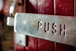 A sign on a door that says “Push”