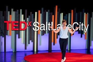 Speaker Robin Konie presenting on the red dot at TEDxSaltLakeCity.