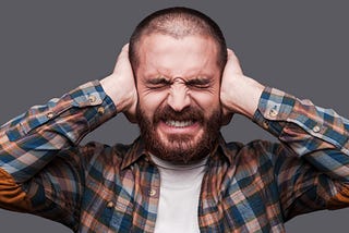 This image shows a man covering his ears so he can’t hear anything.