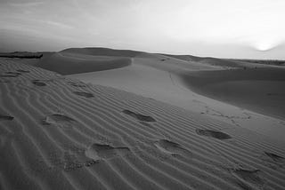 Two sets of footprints in desert dune