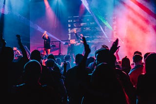 Two musicians on a stage in front of a crowd.