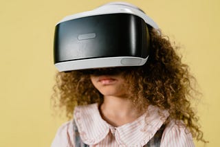 a young girl with curly hair wearing a VR headset