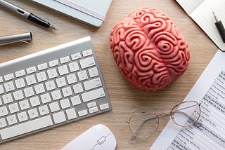 A visual illustration of the human brain by Image by <a href=”https://www.freepik.com/free-photo/top-view-online-psychologist-concept_26389218.htm#from_view=detail_serie">Freepik</a>