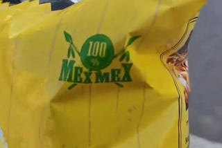 The corner of a bag of nachos. It reads “100% Mex Mex”.