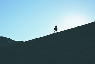 A lone man climbing a mountainside