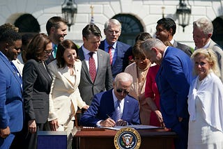 Group of lawmakers around president Biden signing bill