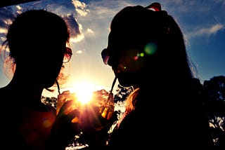 friends sharing a drink in sunset