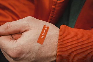 a close up of a human hand with a label “human” on the hand. the background is the person’s torso who is wearing a button down jacket