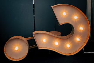 A slightly toppled lighted question mark