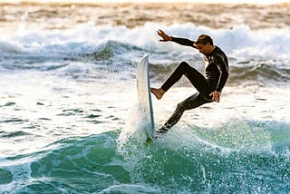 Man surfing, coming vertical off the lip of the wave