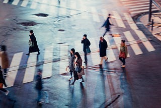 People walking in a crosswalk in a city.
