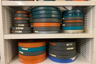 Shelves with piles of variously coloured film canisters.