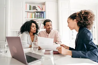 Three people talking at a table.