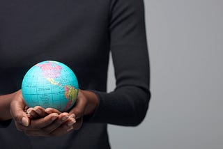 A woman holding a globe in her hands.