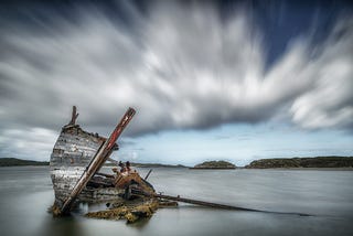 A shipwrecked boat, just poking out above the water