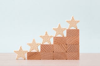 Picture of a stack of blocks forming a stair-step pattern, and on each of the four levels, there is a small wooden star.