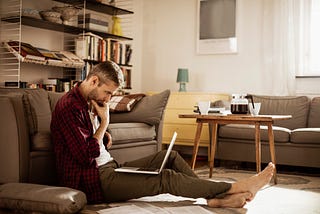 Man ponders in front of his laptop.