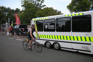 Edward Breen riding a bike beside an ambulance