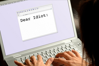 Someone typing an email starting with “Dear Idiot”