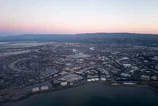 Aerial view of Silicon Valley at dusk, with a portion of the San Mateo/Hayward Bridge visible, as well as Foster City, including the California headquarters of Gilead Sciences, Visa, and Conversica, California, July, 2016.