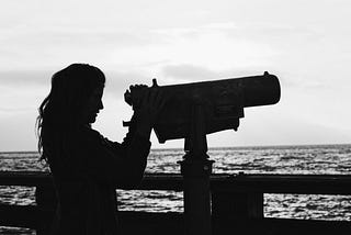 Silhouette of a lady looking into a telescope