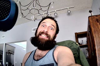 Photograph of Hogan Torah sporting a voluminous beard in an office setting.