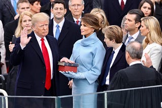 Donald Trump being sworn into office in 2017, hand on Bible.