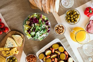 A table setting with healthy food. 9 Best Ways to Control Hunger by Lori Quayle