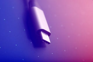 Close-up image of a USB-C cord on a colored background.