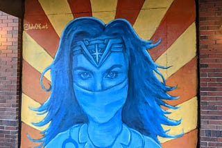 A mural of Wonder Woman wearing a medical mask.