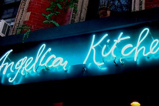 A blue neon sign reading Angelica Kitchen