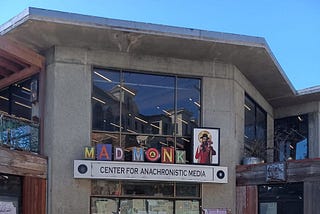 The former Cody bookstore building with its gray concrete walls and large windows in Berkeley, CA on a sunny day.